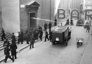 Trieste, 5 novembre 1953: agenti della Polizia civile del Governo Militare Alleato utilizzano un idrante davanti alla chiesa di Sant'Antonio Nuovo durante gli scontri con i manifestanti.